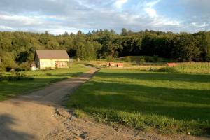 un camino de tierra que conduce a una casa en un campo en Romantic Getaway Cabin on a Working Farm in Royalton, Vermont, en South Royalton