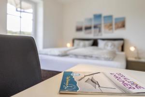 a book sitting on a table next to a bedroom at Haus Wind&Wellen, Wohnung Leuchtturm in Wittdün