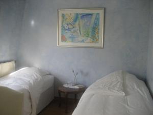a bedroom with two beds and a picture on the wall at 52 Clichy Bed & Breakfast - Chambre d'hôtes in Paris
