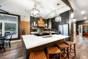 a kitchen with a large white counter and chairs in it at Stunning Rental with Hot-Tub, Theater Room and Great Landscape in Tennessee in Waldens Creek