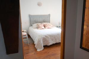 1 dormitorio con 1 cama con 2 almohadas en Gîte Margot, en Vacqueriette