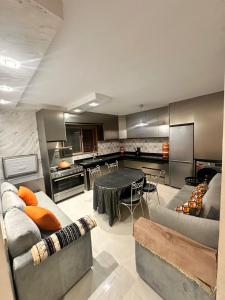 Una sala de estar con una mesa y una cocina. en Belle villa spacieuse et calme avec piscine à 7min de la plage en voiture, en Tamaris