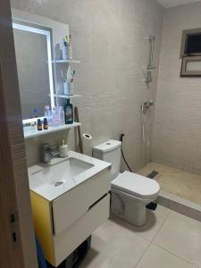 Un baño con un inodoro blanco y un lavabo. en Belle villa spacieuse et calme avec piscine à 7min de la plage en voiture, en Tamaris