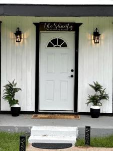 a white front door of a house with a sign on it at Spectacular Secluded Cottage in Round Top, Texas in Ledbetter
