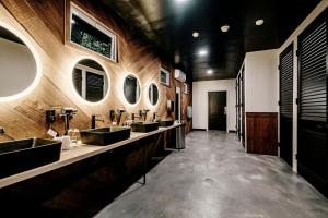 a bathroom with four sinks and a row of mirrors at Magnificent Safari Tent with Sauna and Fire Pit in North Woodstock, New Hampshire in Woodstock