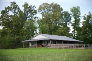 una casa en un campo con una valla en Outstanding Cabin with Hot-tub in Carbondale, Illinois, en Etherton