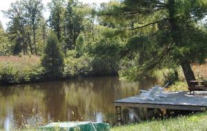 a dock with two chairs and a bench on a lake at Remodeled Cabin Rental Built in 1790 near Scottsville, Virginia in Howardsville