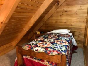 une chambre avec un lit dans un grenier dans l'établissement Secluded Cabin Rental in the Forest near Beckley, West Virginia, à Hico 1 autre photo