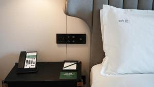 a bed with a phone on a table next to a bed at Holiday Inn Shanghai Pudong Airport, an IHG Hotel in Shanghai
