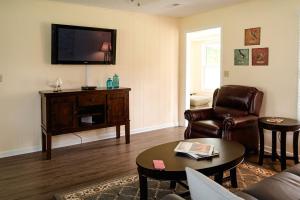 ein Wohnzimmer mit einer Couch und einem Fernseher an der Wand in der Unterkunft Elegant Cottage Rental for Groups near Greensburg, Kentucky in Columbia