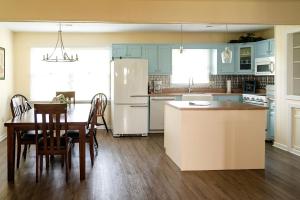 eine Küche mit einem Tisch und einem weißen Kühlschrank in der Unterkunft Elegant Cottage Rental for Groups near Greensburg, Kentucky in Columbia + 8 Fotos