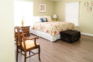 ein Schlafzimmer mit einem Bett, einem Holzstuhl und einem Stuhl in der Unterkunft Elegant Cottage Rental for Groups near Greensburg, Kentucky in Columbia