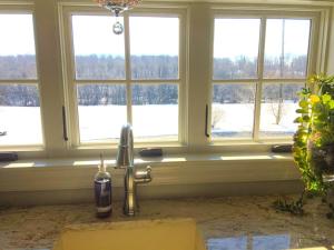 a kitchen with a faucet in front of three windows at Stylish Cottage Loft Rental on a Farm in Lancaster County near Philadelphia, Pennsylvania in Christiana +21 photos
