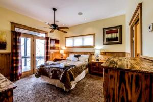 une chambre avec un lit et un ventilateur de plafond dans l'établissement Modern and Cozy Cabin Rental Between Mountains and River in Northern Georgia, à Mineral Bluff