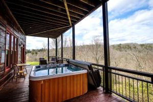 un bain à remous sur la terrasse d'une maison dans l'établissement Modern and Cozy Cabin Rental Between Mountains and River in Northern Georgia, à Mineral Bluff