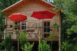 two red umbrellas in front of a wooden cabin at CHALET Meleze Etapeboisee in Fumay