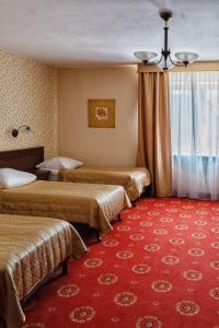 a hotel room with three beds and a red carpet at Anin Park Hotel in Warsaw +84 photos