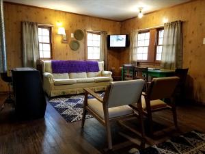 un salon avec un canapé et une table dans l'établissement Delightful Waterfront Cabin with Views of Pine Lake near Wellston, Michigan, à Wellston