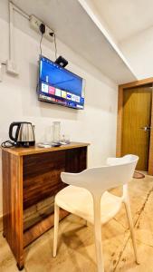a white chair and a television on a wall at TS Club in Trichūr