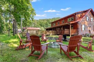 a group of chairs in front of a log cabin at Stunning Cabin with Hot-tub, Fire Pit and Games in Stanton, Kentucky in Stanton