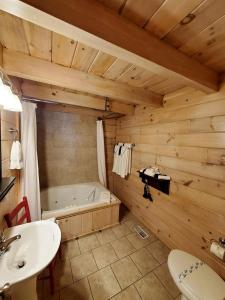 Un baño con bañera, lavabo e inodoro. en Nostalgic Riverside Cabin Haven Near New River, Virginia, en Galax 11 fotos más