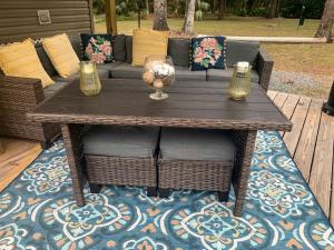 Ein Holztisch und Stühle mit Vasen auf einem Teppich in der Unterkunft Beautiful Cottage with Fire Pit and Barbecue in Dunnellon, Florida in Dunnellon