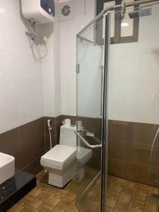 a bathroom with a toilet and a glass shower at Hanoi Valley Boutique Hotel & Travel in Hanoi
