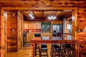 a kitchen with a large wooden island with bar stools at Incredible Pet-Friendly Cabin Located on Top of a Magnificent Mountain in Compton, AR in Compton