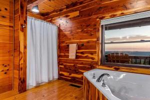 a bathroom with a bath tub and a window at Incredible Pet-Friendly Cabin Located on Top of a Magnificent Mountain in Compton, AR in Compton +27 photos