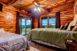 a bedroom with two beds in a log cabin at Incredible Pet-Friendly Cabin Located on Top of a Magnificent Mountain in Compton, AR in Compton