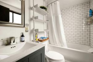 a bathroom with a toilet and a tub and a sink at Enchanting A-Frame Cabin Retreat near Berkeley Springs and Mountain Views in West Virginia in Baxter