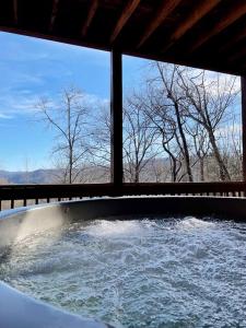a tub filled with water in front of a window at Lake Cabin Fully Equipped Ideal for Big Families in Topton, North Carolina in Aquone