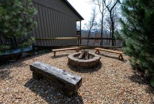 einen Hinterhof mit zwei Bänken und einer Feuerstelle in der Unterkunft Lake Cabin Fully Equipped Ideal for Big Families in Topton, North Carolina in Aquone