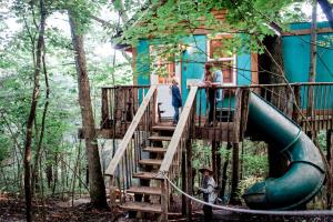 a tree house with a slide in the woods at Enchanting Tree House with a Slide on 200 Acres for a Family Adventure in Germantown, Kentucky in Germantown