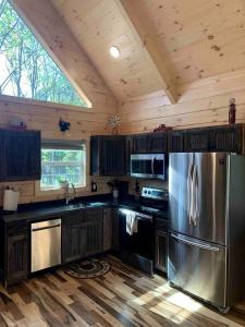 eine Küche mit einem Edelstahlkühlschrank in einer Kabine in der Unterkunft Fantastic Secluded Cabin with Fire Pit and Hot-tub in Campbellsville, Kentucky in Campbellsville