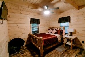 ein Schlafzimmer mit einem Bett in einer Blockhütte in der Unterkunft Secluded Wooden Cabin with Fire Pit, Barbecue and Hot-tub in Campbellsville, Kentucky in Campbellsville