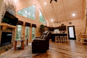 ein Wohnzimmer mit Couch und Kamin in der Unterkunft Secluded Wooden Cabin with Fire Pit, Barbecue and Hot-tub in Campbellsville, Kentucky in Campbellsville