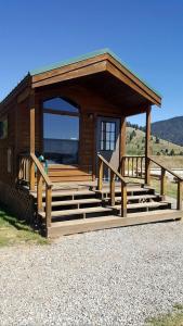 a small cabin with stairs and a porch at Outstanding Lakefront Cabin with Fire Pit near West Yellowstone, Montana in Lakeview
