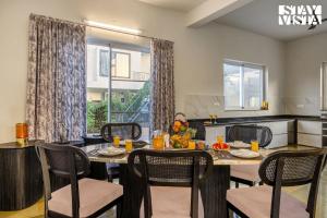 a kitchen and dining room with a table and chairs at StayVista at Vacanza Villa - Pool, Lawn & Theatre in Jaipur