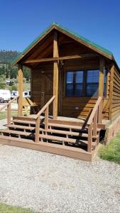 a log cabin with a porch and a building at Charming Wooden Cabin with Fire Pit near West Yellowstone, Montana in Lakeview