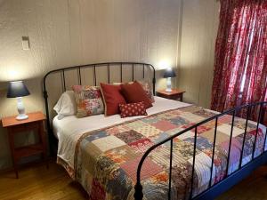 une chambre avec un lit avec une couette et deux lampes dans l'établissement Elevate Your Holidays: Glamping at Cypress Creek Cottage, Texas' Hidden Gem, à Wimberley