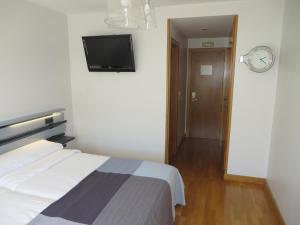 a bedroom with a television and a bed at Toctoc Rooms in A Coruña