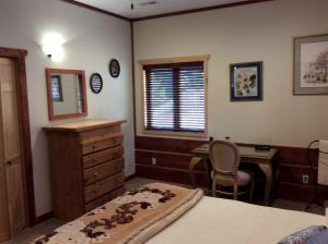 Dormitorio con escritorio, cama y sofá cama en Gorgeous Bed and Breakfast Suite near Elk City in Wilderness of Central Idaho, en Elk City