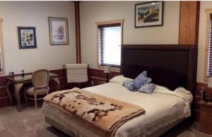 Un dormitorio con una cama, un escritorio y una mesa. en Gorgeous Bed and Breakfast Suite near Elk City in Wilderness of Central Idaho, en Elk City