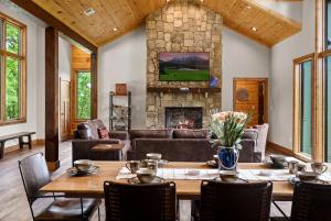 a living room with a table and a stone fireplace at Fantastic Cabin with Pool Table and Games in Gartlinburg, Tennessee in Chalet Village +52 photos