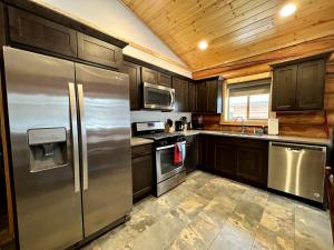 a kitchen with stainless steel appliances and wooden cabinets at Spacious Pet-Friendly Log Cabin with King Bed & Full Kitchen | Bonners Ferry, Idaho Retreat in Bonners Ferry