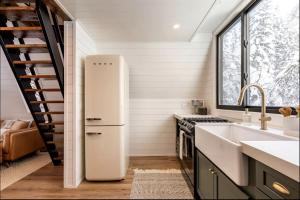 a kitchen with a white refrigerator and a sink at Lovely Secluded A-frame with Hot-tub in Sundance, Utah in Sundance