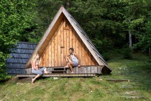 Dos personas sentadas en una gran casa de madera. en Lovely Retreat for Adventurous Getaways in Slovenia, en Soča