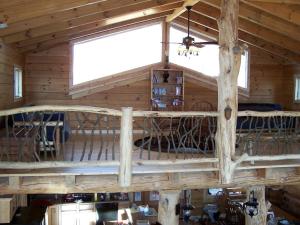 - une mezzanine dans une cabane en rondins dotée d'une fenêtre dans l'établissement Luxury Vacation Rental with a Hot Tub for Rent in Clyde, North Carolina, à Crabtree