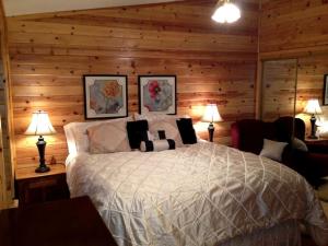 a bedroom with a large bed in a log cabin at Cozy Vacation Cottage Rental near Lassen Volcanic National Park, Northern California in Shingletown